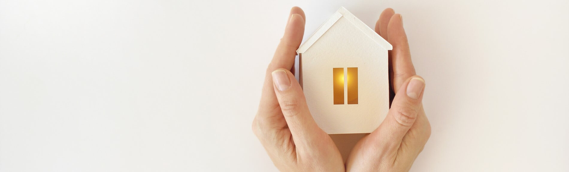 Hands holding miniature wooden house